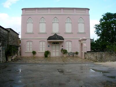 A two-story pink building with white accents