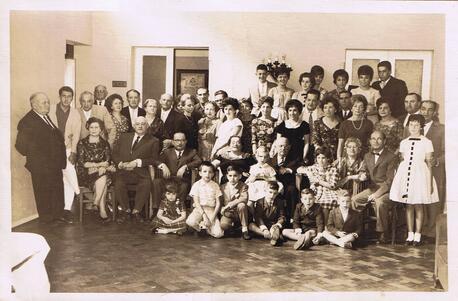A large group of children and adults in formal clothing, posing for a photo