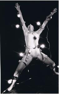 Ruth Eshel with arms and legs spread wide, wearing a number of light bulbs on belts attached to her limbs and torso