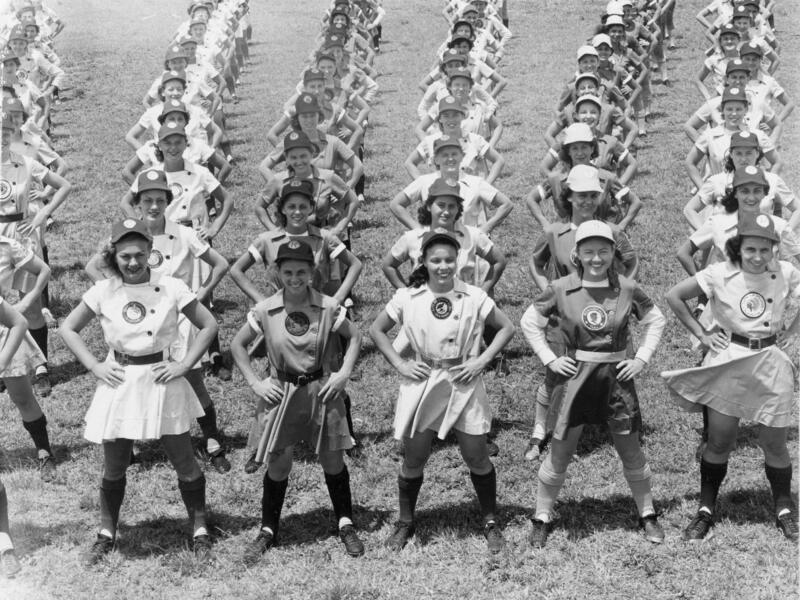 Rows of young women in baseball uniforms with hands on hips