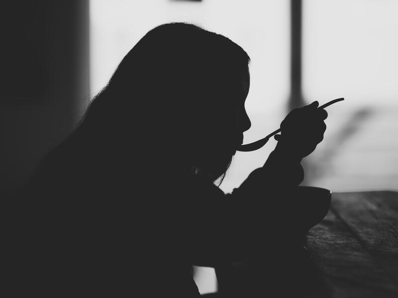Silhouette of Girl Eating from a Spoon