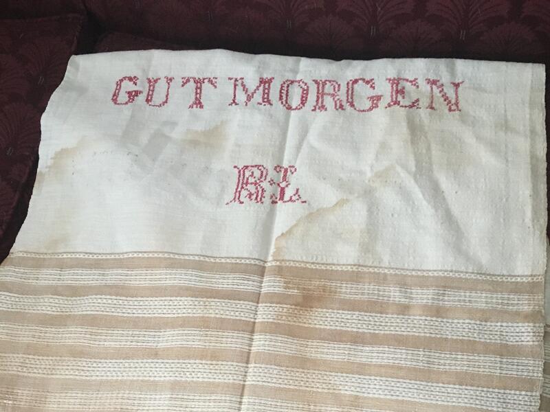 A white cloth with the words "Gut Morgen" (Good Morning in Yiddish) followed by the initials R.L.
