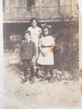 Bessie Margolin, Dora and Jack posed in a group picture in a courtyard with building with a porch visible in the background