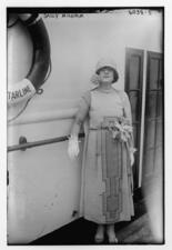 Sall Milgrim wearing a day dress and gloves, standing next to a railing and a lifesaver on the wall labeled "Starline"