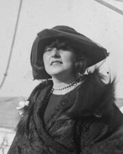 Cropped photo of Sally Milgrim outdoors, wearing a coat with a fur wrap and a hat