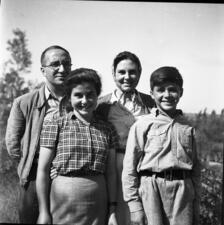Four members of the Sereni family stand and pose for a portrait. Father Enzo Sereni and mother Ada Ascarelli Sereni stand behind two of their children, Hagar and David. 