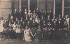 A group of young Beis Yaakov girls, posed in rows for a school photo. 