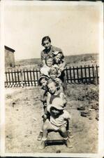 Six children and their teacher pose on a slide.