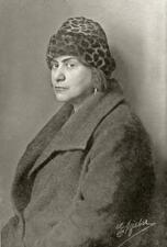 Studio portrait of Else Lasker-Schüler, wearing a coat and a leopard-print hat