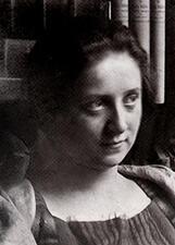 Portrait of Friedl Dicker-Brandeis as a young woman, sitting in front of a bookshelf