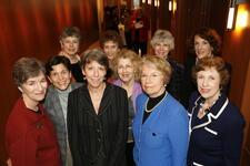 A group of ten women posing in a hallway.