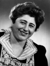 Gertrude Berg in costume as Molly Goldberg looking into camera and smiling 