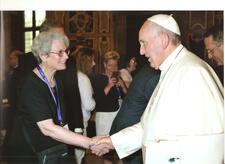 Nadine Iarchy, wearing an ICJW lanyard, shaking hands with Pope Francis