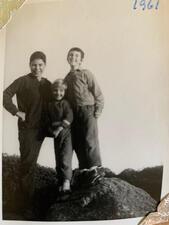 Marjorie Agosin as a child, standing with two friends on a large boulder