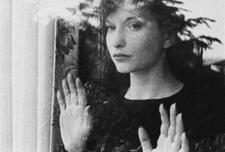 Still of  Maya Deren looking out of a window from the 1943 short film Meshes of the Afternoon