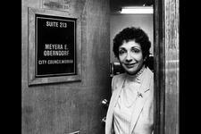 Meyera Oberndorf standing in the opening of a door reading: Suite 213 Meyera E. Oberndorf City Councilwoman