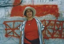 Ze'eva Cohen in front of a graffitied wall