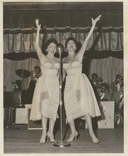 Black-and-white photo of two women on stage