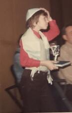 Carole Balin dressed as a bar mitzvah boy, in a tallit, kippah, carrying kiddush cup