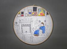 Embroidery hoop art depicting a figure reading by a fire in a cozy room with art on the walls