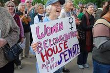 Woman Holds Sign Reading "Women Belong in the House and the Senate," 2012