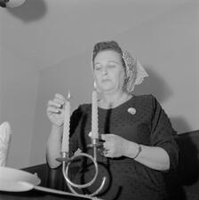Housewife welcomes the Sabbath on Friday evening before the meal. Israel, 1963.