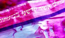 Close up image of Shoshanah Curiel-Alessi's tie-dyed pink and purple tallit