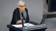 Ruth Klüger leaning against a podium labeled Deutscher Bundestag