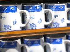 souvenir name mugs featuring illustrated fish. Names "Eva" and "Hanna" are on the mug.