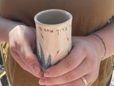 Close up of hands holding Miriam's Cup