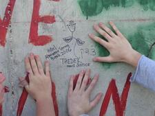 Children Place Hands on Wall with Message about Justice