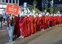 Women in red robes and white caps marching in protest, evoking the Handmaid's Tale