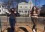 Two teens wearing masks on swings at playground