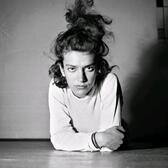 Eva Besnyö leaning on her elbows on the floor, with her hair up