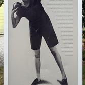 A sign with a picture of Lilli Henoch preparing for the shot put, with a brief biography written in German
