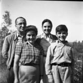 Four members of the Sereni family stand and pose for a portrait. Father Enzo Sereni and mother Ada Ascarelli Sereni stand behind two of their children, Hagar and David. 