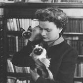 Ella Morante in her apartment, holding two of her cats. 