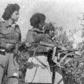 Three women in uniform stand holding rifles