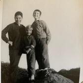 Marjorie Agosin as a child, standing with two friends on a large boulder