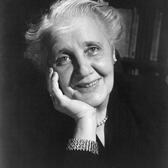 An older Melanie Klein, smiling with her face in her hand