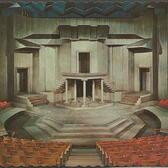 A drawing of a stage surrounded by red seats, with a grey, cubist set design featuring three doorways, several staircases, and a balcony held up by five pillars