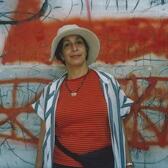 Ze'eva Cohen in front of a graffitied wall