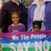 Marla Brettschneider and Family with Anti-Bush Banner, 2004