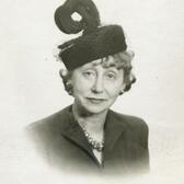 A portrait of Adeline Schulberg wearing a black hat