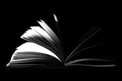 Open book with flipping pages. Black background.