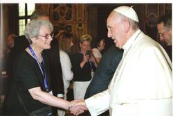 Nadine Iarchy, wearing an ICJW lanyard, shaking hands with Pope Francis