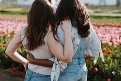 Women with arms around each other, backs turned