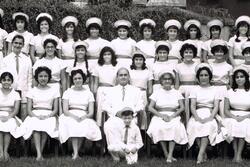 A large group of people in white costume, wearing hats or kippahs; primarily women, but including a few men and children as well
