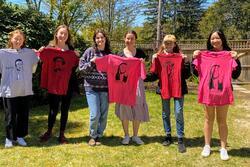 Rising Voices Fellows holding up T-shirts with feminists on them