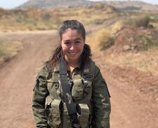 Young woman in military uniform posing outdoors